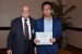 Dr. Nagib Callaos, General Chair, giving Mr. Jiaxin Ge the best paper award certificate of the session "Applications of Informatics in Management, Computer, Finance and Economy I." The title of the awarded paper is "Development and Application of Audio/Video Syncing Server for Areal Online Education."